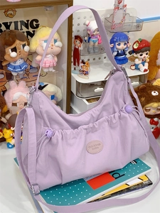 Détail du sac cabas en nylon lavande avec logo et poches latérales à cordon