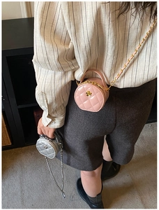 Gros plan de mini sacs ronds matelassés rose et argent avec détails floraux dorés