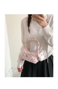 Détail du sac à bandoulière rose avec broderie florale, anse nuage et breloque lapin mignonne