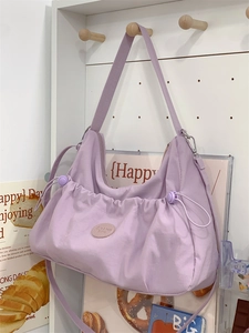 Détail d'un sac cabas en nylon lilas avec poches à cordon plissées et boucle en métal argenté
