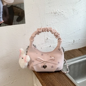 Détail du sac à main croissant rose avec poignée plissée, imprimé fleuri et breloque lapin