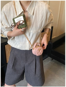 Détail d'un mini sac bandoulière rond en cuir matelassé rose avec bandoulière dorée