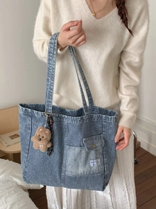 Blue striped denim canvas tote bag with outer pockets and brown teddy bear charm