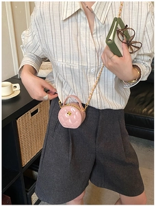 Détail du mini sac rond rose matelassé avec boucle fleur dorée et bandoulière chaîne