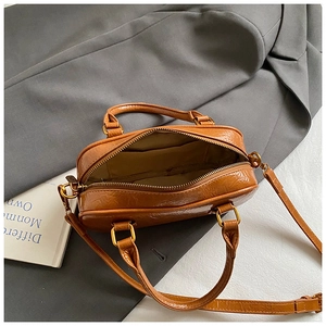 Detailed interior of a vintage brown leather bowling bag with gold zipper and inner pocket