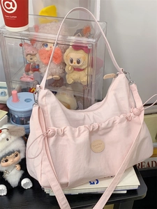 Détail du sac cabas rose froncé avec cordons de serrage et écusson de logo en cuir rond