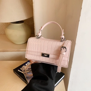 Pink crocodile pattern top-handle bag with a metallic twist lock and adjustable shoulder strap