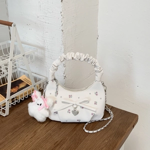 Détail du sac dumpling blanc à fleurs avec poignée plissée, nœud et charm lapin en peluche