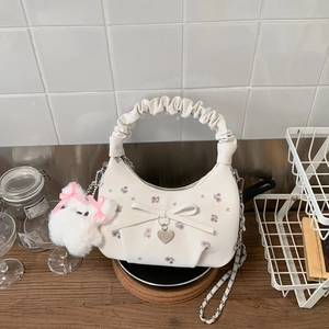 Détail de la broderie florale et du pendentif cœur sur le sac à main en PU blanc
