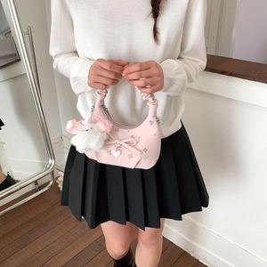 Détail du sac rose avec broderie florale, nœud et pendentif en peluche d'ours