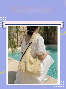 Detail view of a fluffy beige tote bag with star motifs on a model by the pool
