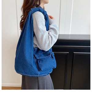 Seitenansicht der großen Denim-Hobo-Tasche mit Frontklappentasche an einem Model
