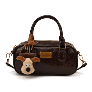 Retro dark brown glossy leather bowling bag with gold plaque and plush dog charm