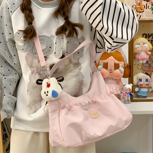 Détail du sac cabas rose en nylon avec fronces à cordon et charmant pendentif chien en peluche