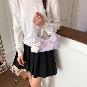 Détail du sac lavande brodé de fleurs avec nœud rose, anse nuage et charm lapin blanc