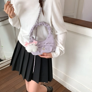 Détail du sac hobo lilas avec un pendentif en peluche et un nœud 3D élégant