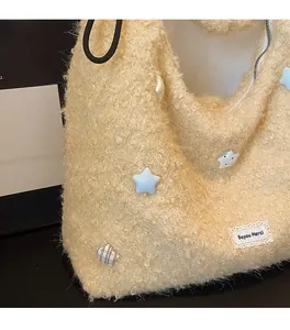 Detail of soft cream sherpa tote bag featuring star patches and a lace woven label
