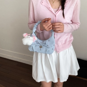 Détail du sac à main floral avec nœud, pendentif en cœur et breloque lapin en peluche