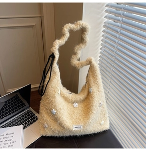Detail of off-white plush tote featuring unique wavy handle and 3D star decorations