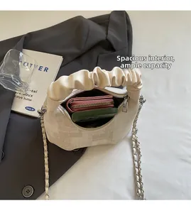 Detail view of cream dumpling bag with spacious interior for phone and red wallet