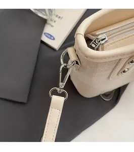 Détails du sac seau beige montrant les finitions métalliques et le tissu texturé