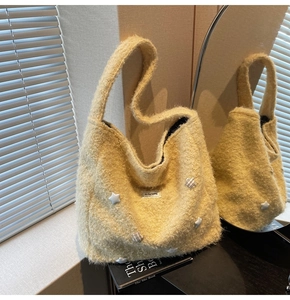 Detail of yellow fuzzy teddy tote bag featuring white 3D stars and soft textured fabric