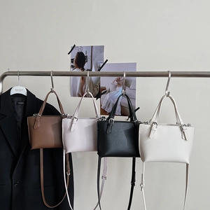 Minimalist bucket bags in brown, pink, black, and white colors with litchi grain texture
