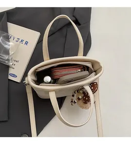 Vue de dessus montrant l'intérieur spacieux d'un sac cabas blanc cassé avec fermeture