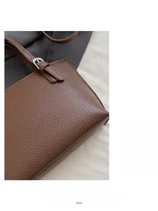 Close-up of brown litchi pattern leather texture and silver metal buckle on bucket bag