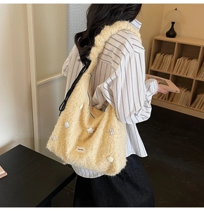 Close-up of fluffy beige tote bag with star patches and soft teddy fleece texture