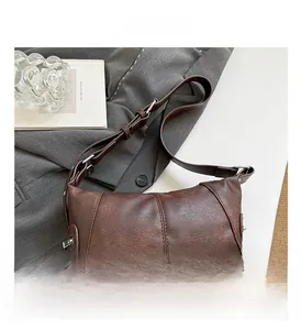 Close-up of the dark brown leather texture and adjustable strap on this shoulder bag