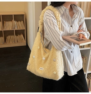 Close-up of yellow fuzzy tote bag showing plush texture and star button detail