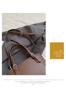 Detail of adjustable litchi texture leather strap with silver buckle on a brown bag