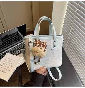 Détail du sac seau en toile bleu clair avec bordure PU et pendentif peluche mignon