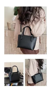 Detail of black lychee grain leather bucket bag with silver hardware and shoulder strap