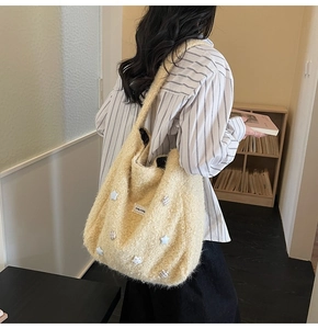 Macro detail of soft cream faux fur tote bag with star and striped ball patches