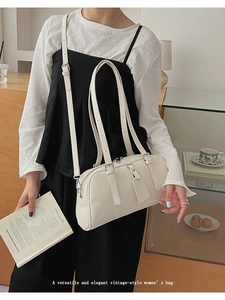 Detail of white vintage underarm bag with thin handles and adjustable strap in lifestyle setting