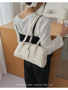 Cream white vintage Boston bag with adjustable shoulder strap shown in a lifestyle setting