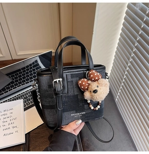 Détail du sac bandoulière gris avec bordure en cuir et joli pendentif ours en peluche
