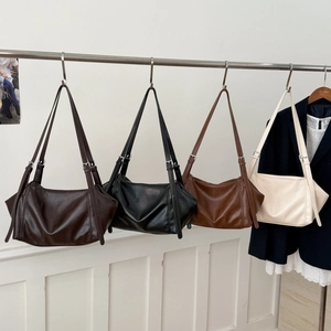Detailed display of four textured faux leather tote bags in various colors on a rack