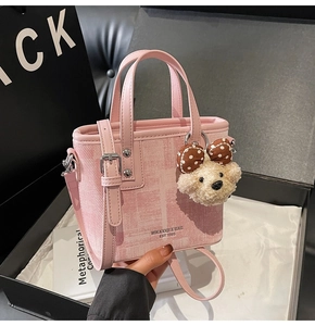 Détail du sac seau rose clair texturé avec bandoulière et charmant petit ours