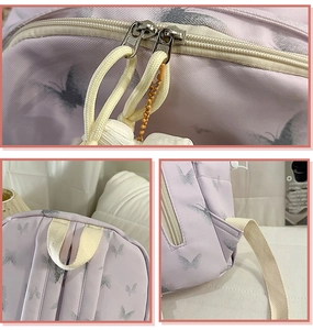 Detail view of purple nylon school bag featuring metal zippers and soft butterfly print