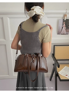 Detail view of dark brown vintage Boston bag showing matte oil wax leather and metal buckle