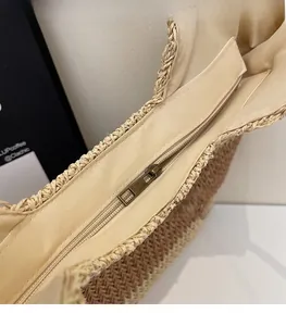 Detailed macro view of woven straw tote bag featuring a durable bronze zipper closure