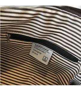 Detail of internal striped fabric lining and secure zipper pocket in a tote bag