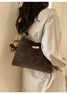Sac cabas vintage marron foncé en daim avec fermoir doré sur un mannequin femme