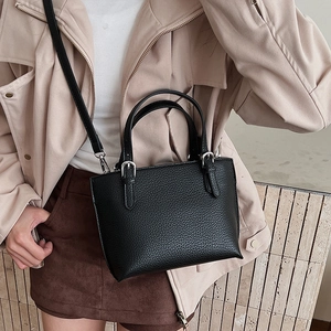 Close-up of black lychee grain bucket bag featuring silver hardware and a detachable strap