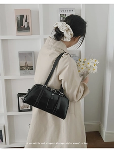 Minimalist black retro underarm bag shown in a lifestyle setting on a model