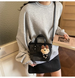 Détail du sac seau bicolore avec pendentif ours en peluche et bandoulière fine