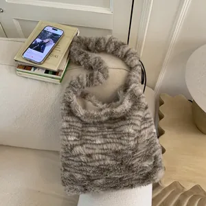 Detail view of striped faux fur shoulder bag resting on a cream fabric sofa